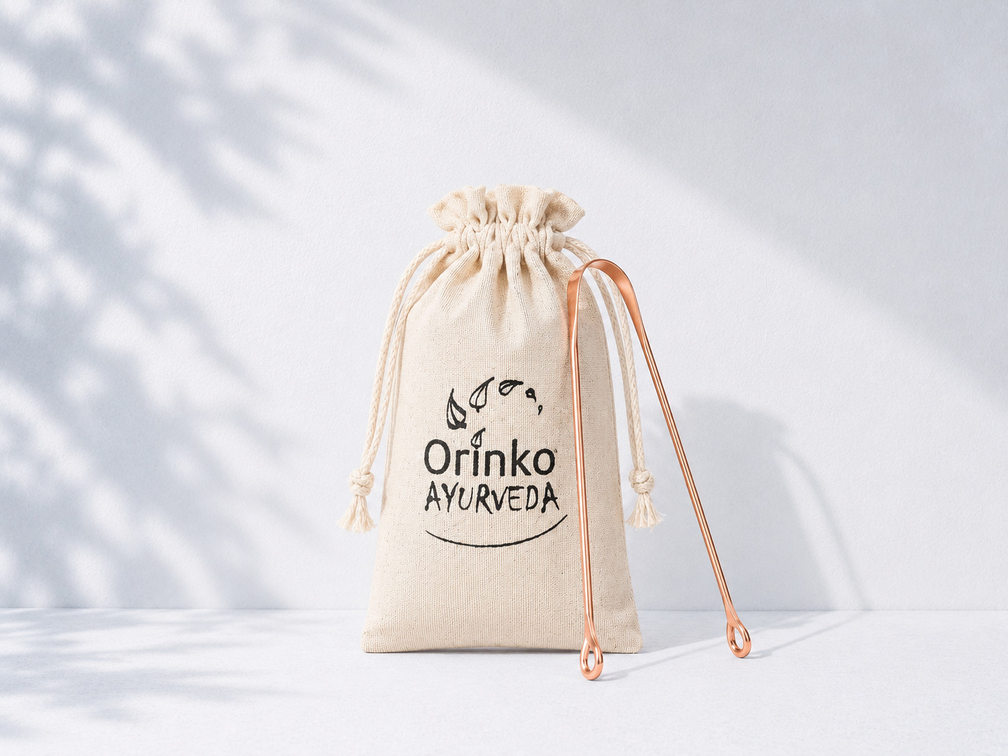 A single copper tongue scraper in its individual cotton pouch, ready for retail